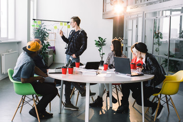 Group of casually dressed businesspeople discussing ideas in the office. Creative professionals gathered at the meeting table for discuss the important issues of the new successful startup project