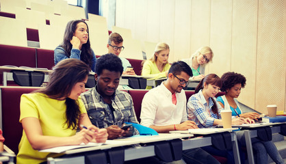 education, high school, university, technology and people concept - group of international students with smartphones and coffee at lecture