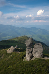 Fototapeta na wymiar Freakish rocks among green mountains