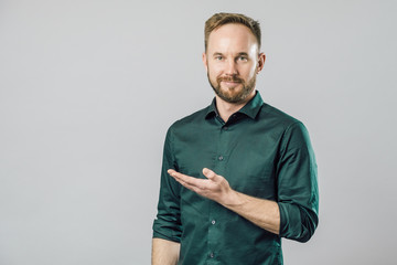 Portrait of cheerful young man smiling pointing finger