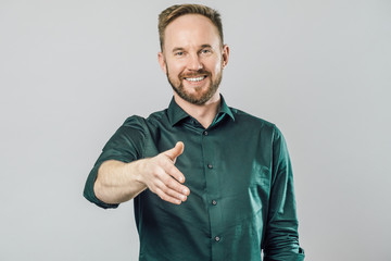 Young handsome man offering handshake