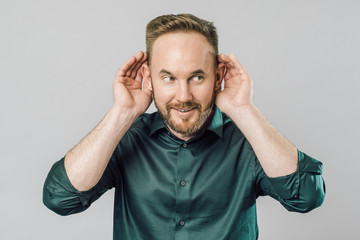Fototapeta premium Man with hand over ear listening and hearing to rumor or gossip