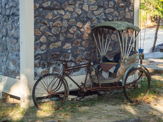 Fototapeta na wymiar Vintage bicycle with a sidecar stands at the wall of the house
