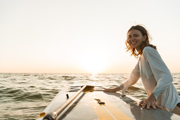 Beautiful smiling young woman using a stand up paddle board - obrazy, fototapety, plakaty