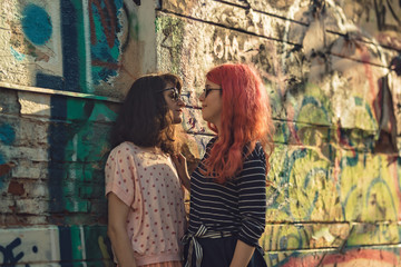 two lesbian girls, couple kiss romantically on the street in the city show love to each other gay pride LGBT pride world movement lesbian, gay, bisexual, transgender proud of their sexual orientation