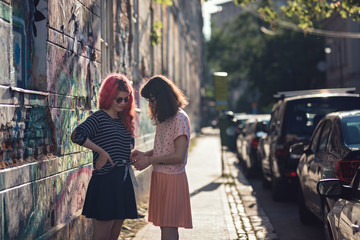 two lesbian girls, couple kiss romantically on the street in the city show love to each other gay pride LGBT pride world movement lesbian, gay, bisexual, transgender proud of their sexual orientation