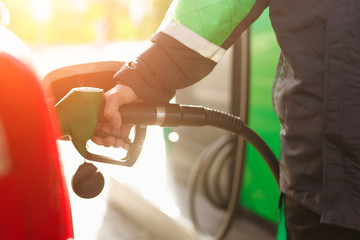 Crop employee filling car with fuel