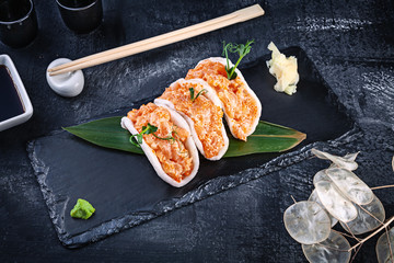 modern serving tuna salmon with avocado in rice chips. healthy food. raw seafood. raw tuna with microgreen and Tobiko caviar. Beautiful food served on dark background. japanese food style