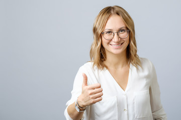 Young happy smiling cheerful woman showing thumbs up