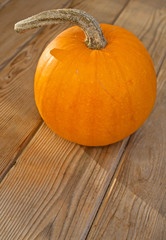 Fall pumpkin on a wooden surface. Perfect for baking or carving a jack o'lantern.