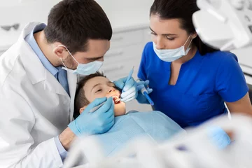 Foto auf Acrylglas Zahnärzte Medizin-, Zahn- und Gesundheitskonzept - Zahnarzt mit Mundspiegel und Sonde, die in der Zahnklinik auf die Zähne von Kinderpatienten überprüft