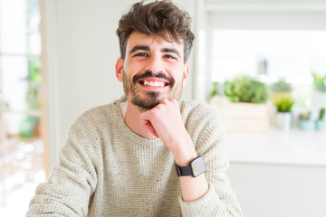 Handsome young man smiling cheerful at the camera with a big smile on face showing teeth