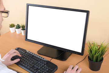  Businessman looking at computer screen using a desktop computer with a view over his shoulder from behind of the blank screen of the monitor with copy space,text
