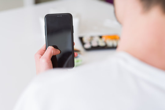 Close upf man using smartphone to orden take away asian food from delivery
