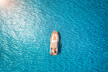 Aerial view of luxury yacht in transparent blue sea at sunset in summer in Mallorca, Spain....