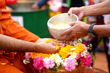 Close-up Hands holding a bowl of water to pour Buddha in the Songkran tradition. Hands of thai people pouring water (bathing) on Buddha Songkran festival. Songkran is new year of Thailand..