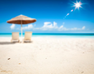 Summer background of beach with yellow sand and umbrella 