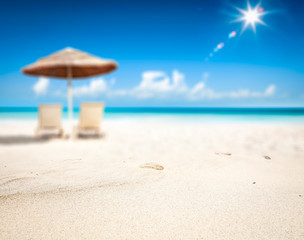 Summer background of beach with yellow sand and umbrella 
