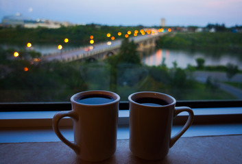 Romantic view of a bridge in the morning with two hot coffees sitting on a window ledge