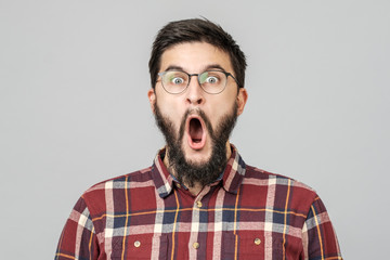 Thrilled excited guy in glasses isolated over gray