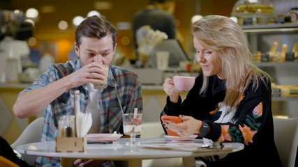 Young man and woman having coffee together