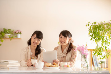 タブレットPCを持ち微笑む2人の女性