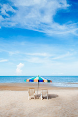 Beach beds and colourful umbrella with ocean horizon view and clear sky slightly clouds in summer