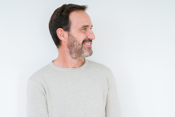 Fototapeta premium Elegant senior man over isolated background looking away to side with smile on face, natural expression. Laughing confident.
