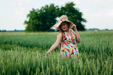 Pregnant girl in the evening in a wheat field