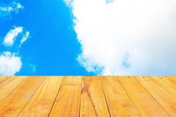 Old Wooden table with blue sky white cloud background.