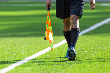 Football Assistant Referee walking with Flag