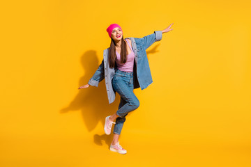 Full length body size view photo of lovely glad millennial she her good-looking weekend rest relax dressed singlet modern outfit sneakers isolated colorful yellow background