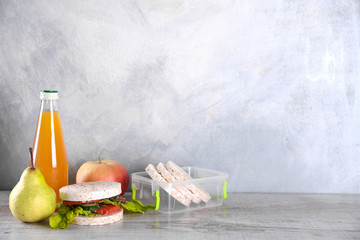 lunch for your child in school, box with a healthy sandwich and fruit salad and apple juice in the bottle for drinking