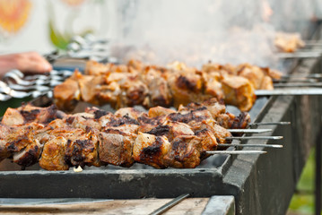 Slice pieces of meat on the grill. barbecue at the festival. Cheese and roasted veal on skewers.