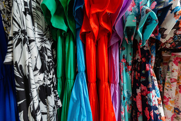 Cocktail dress. Clothing on hanger at the modern shop boutique. Bright multi-colored fabrics. concept of shopping.