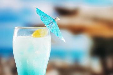 Blue chilled drink in glass decorated with umbrella