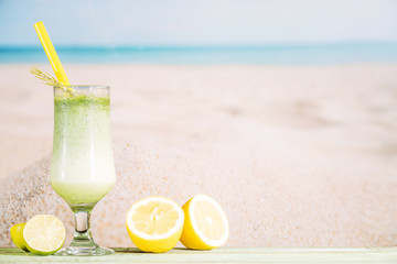 Glass of fresh green smoothie and sliced citrus