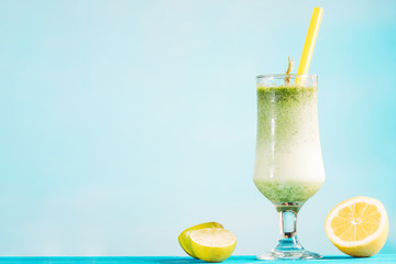 Glass of creamy green smoothie and sliced citrus