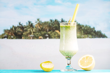 Glass of tropical sour smoothie and sliced citrus