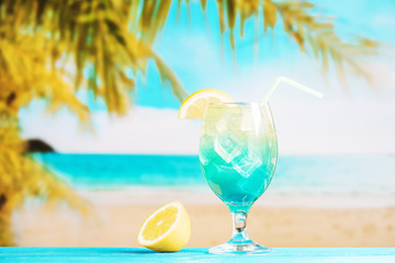 Glass of fresh blue drink with straw and sliced lime