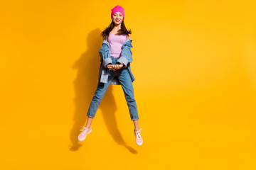 Full length body size photo beautiful amazing she her lady hands arms together jump high sporty day off mood cool look wear casual jeans denim jacket shoes pink hat isolated yellow bright background