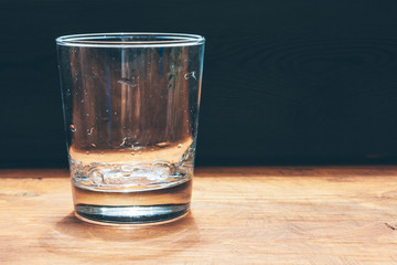 Glass of water on dark background close up