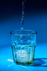 Close up pouring purified fresh drink water from the bottle on table