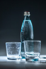 Served table set of mineral water bottle and glass