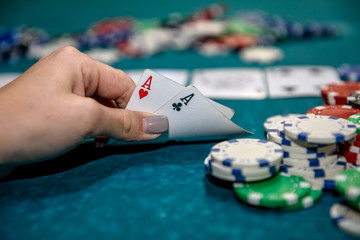 Female hand with playing cards and poker chips close up