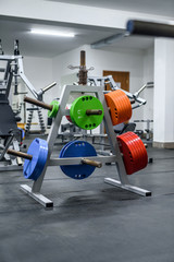 Fototapeta na wymiar Colorful weights in gym for training with barbell
