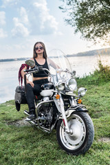 Fototapeta na wymiar Beautiful woman posing with helmet and motorcycle
