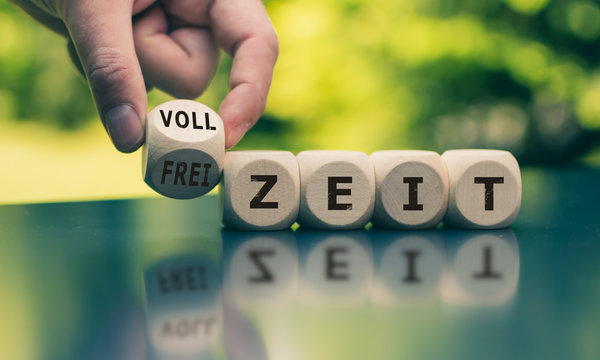 Hand dreht einen W&uuml;rfel und &auml;ndert das Wort "Vollzeit" in "Freizeit" oder umgekehrt. 
