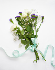 bouquet with white roses. with a blue satin ribbon .on a white background .concept gift for a woman. Concept work of the flower girl.