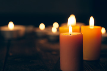candles burning in darkness over black background. commemoration concept.